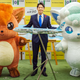 A man in a suit shows off a model plane version of the Vulpix plane and is flanked by two people dressed as Vulpix.